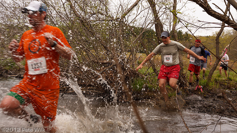 Runners splashing through the final water crossing a few hundred yards from the finish.