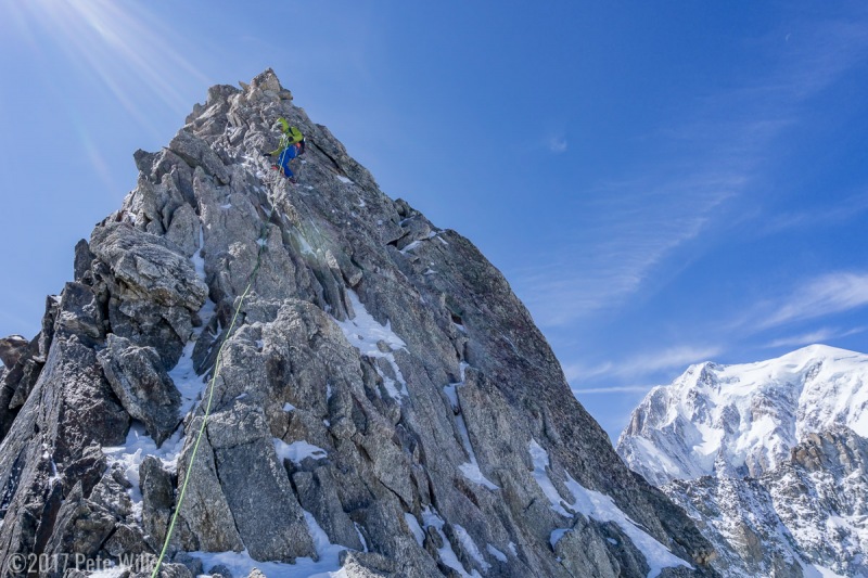 The route includes a couple minor downclimbs.  Here has the duty of cleaning the last but of protection I placed.  Mont Blanc in the background.
