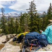 The terrain between the peaks and us is a complex mixture of bedrock, light forest, streams, and ponds.  Carly points out the prominent peaks.